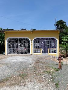 a yellow house with two gates in front of it at 25 Spice in Port Antonio