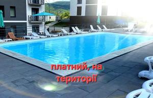 a swimming pool at a hotel with lounge chairs at Апартаменти в "Арена Віладж" in Polyana