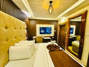 a hotel room with a large bed and a mirror at Presken Hotel Mojidi, Allen Ikeja in Ikeja