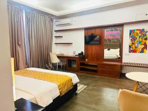 a bedroom with a bed and a desk and a television at Golden Pearl Tangalle Beach in Tangalle