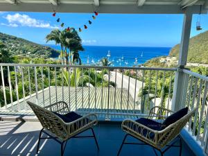 a balcony with chairs and a view of the ocean at O Coeur de Deshaies Appartements Grande Anse et Amandiers in Deshaies