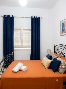 a bedroom with a bed with blue curtains at house in rafraf beach in Rafrāf