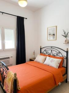 an orange bed in a bedroom with a window at house in rafraf beach in Rafrāf