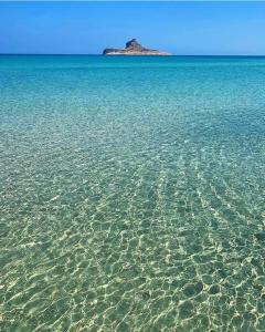 a large body of water with an island in the background at house in rafraf beach in Rafrāf