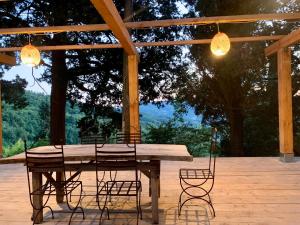 a wooden table and chairs on a patio with lights at La Felce e il Mirtillo in Il Palazzo