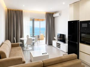 a living room with a couch and a tv and a table at Apartment Katherina Sarande in Sarandë