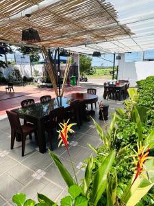 a patio with a table and chairs under an umbrella at Vital Point Kampot in Kampot