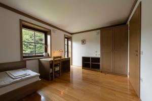 a bedroom with a bed and a desk and a window at Karami Mountainhouse in Tržič +67 photos