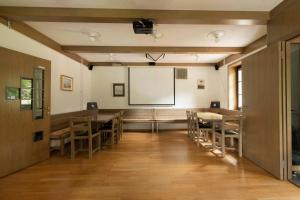 a large room with tables and chairs and a projector screen at Karami Mountainhouse in Tržič