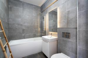 a bathroom with a white toilet and a sink at N31 Pipera Executive Apartment in Voluntari +23 photos