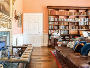 a living room with a couch and book shelves with books at Kyre Park in Tenbury +19 photos