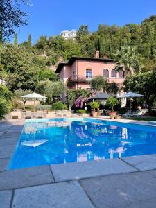 a swimming pool in front of a house at Villa Lou in Toscolano Maderno