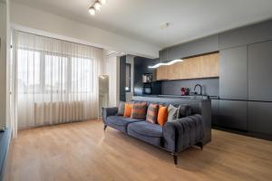 a living room with a couch and a kitchen at N31 Pipera Executive Apartment in Voluntari