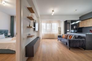 a bedroom with a bed and a couch in a room at N31 Pipera Executive Apartment in Voluntari