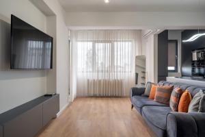 a living room with a couch and a television at N31 Pipera Executive Apartment in Voluntari