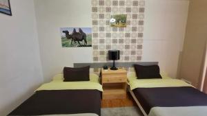 a room with two beds and a picture of a horse at Crystal House Hotel in Buyant-Uhaa