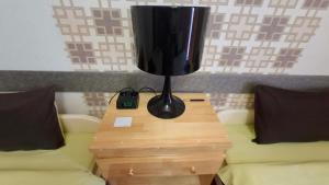 a lamp sitting on a table next to two beds at Crystal House Hotel in Buyant-Uhaa