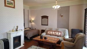 a living room with a couch and a bed and a fireplace at Crystal House Hotel in Buyant-Uhaa