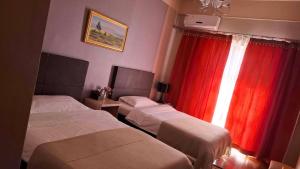a hotel room with two beds and a red curtain at Crystal House Hotel in Buyant-Uhaa