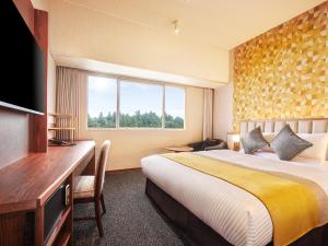 a hotel room with a bed and a window at Art Hotel Narita in Narita