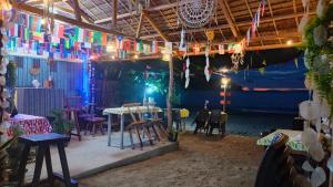 a room with tables and chairs and colorful flags at Kubo Inn & Beach Camp in El Nido
