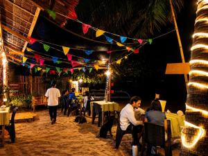 a group of people sitting in a restaurant at night at Kubo Inn & Beach Camp in El Nido