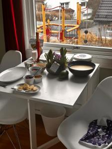 a table with plates of food on it with a window at Asleep in the Valley Villa in Oslo