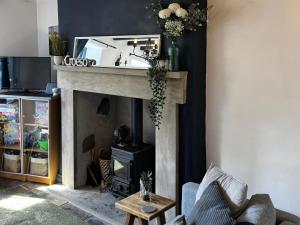 a living room with a fireplace with a mirror over it at Mynydd A Môr in Trevor