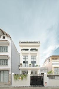 a white apartment building with a black gate at Amazing Studio Boutique Hotel in Hanoi