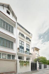 an apartment building with a white facade at Amazing Studio Boutique Hotel in Hanoi +32 photos