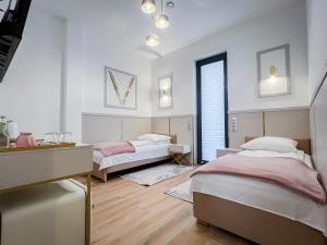 a bedroom with two beds and a desk at VENETIA-Rooms in Biecz