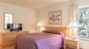 a bedroom with a bed and a flat screen tv at Wapato Point Resort in Manson
