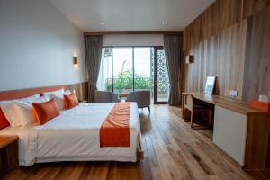a hotel room with a bed and a desk at Stadion Residences in Phumĭ Prêk Chrey