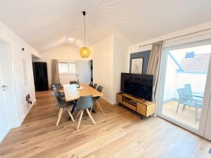 a dining room with a table and a television at Casa Materi Werneck in Werneck