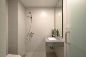 a white bathroom with a shower and a sink at Amazing Studio Boutique Hotel in Hanoi