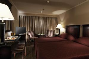 a hotel room with a bed and a desk and chairs at JAZ Crown Jubilee Nile Cruise - Every Thursday from Luxor for 07 & 04 Nights - Every MondayFrom Aswan for 03 Nights in Luxor
