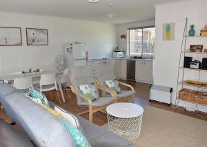 a living room with a couch and a table at Barefoot Bungalow in Tomakin