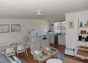 a kitchen and living room with a table and chairs at Barefoot Bungalow in Tomakin