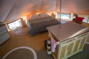 a bedroom with a bed in a tent at La Permaculturelle - Domaine des Ramières in Le Poët-Laval