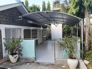 an open gate to a house with two potted plants at Mobi house Malindi in Malindi