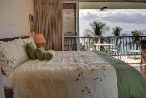 a bedroom with a bed with a view of a balcony at Mana Kai 710A in Wailea