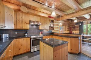 a large kitchen with wooden cabinets and a stove at Fiddler Lake Resort - Moose 93 in Mille-Isles +24 photos