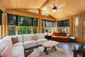 a living room with a couch and a ceiling fan at Fiddler Lake Resort - Moose 93 in Mille-Isles