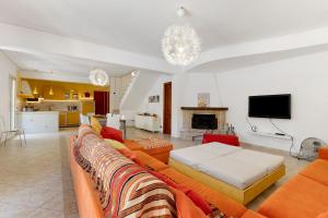 a living room with a couch and a tv at Villa Magda - private pool 20 pax in Marina di Ragusa