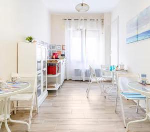 a dining room with white tables and chairs at OLTREMARE in Scalea