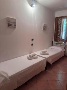 two beds sitting next to each other in a room at Peperoncino Home in Pedeguarda