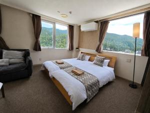 a bedroom with a large bed and a couch at 雪场缆车站旁 Hotel Justice-Ski IN Ski OUT-独立卫浴 in Seki +65 photos