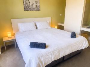 a large white bed with two blue towels on it at Townhouse 7 - Located at FOOTPRINTS PRESTON BEACH RESORT in Preston Beach +50 photos