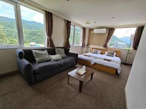 a living room with a couch and a bed and a bed and window at 雪场缆车站旁 Hotel Justice-Ski IN Ski OUT-独立卫浴 in Seki