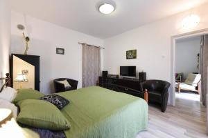 a bedroom with a green bed and a desk at Apartments Dado in Zadar